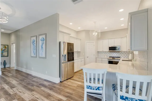 a kitchen with stainless steel appliances granite countertop a refrigerator and a stove top oven