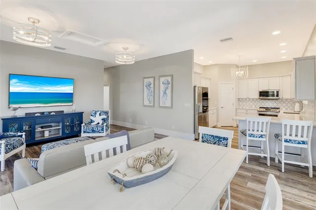 a living room with furniture kitchen view and a flat screen tv