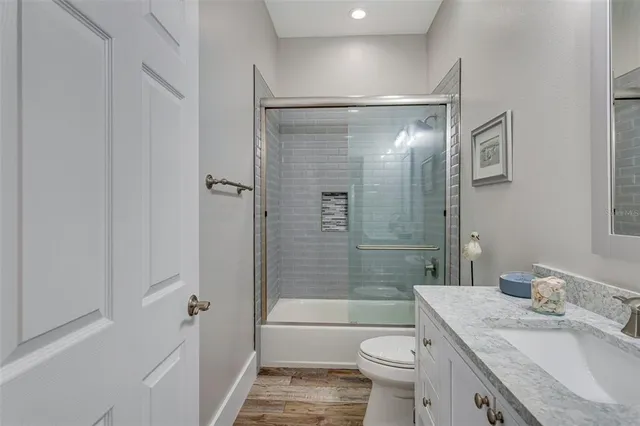 a bathroom with a granite countertop sink toilet and shower