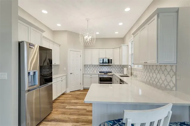 a kitchen with stainless steel appliances a refrigerator and a stove top oven