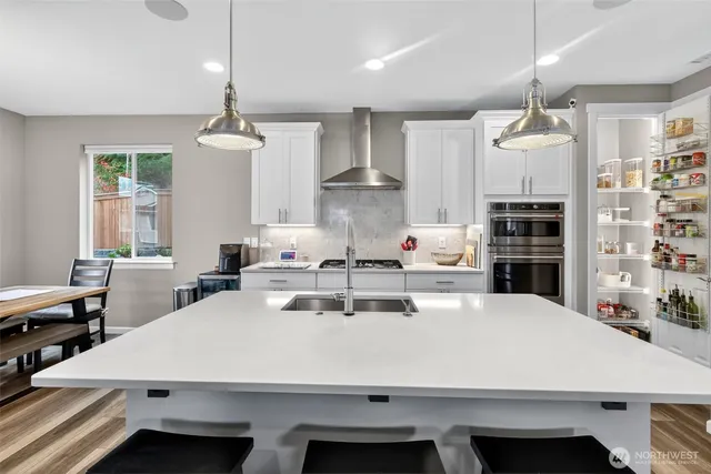 a kitchen with a table a refrigerator and cabinets