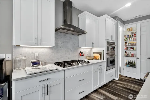 a kitchen with stainless steel appliances a cabinets and a stove top oven