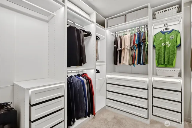 a view of walk in closet with clothes and shoes