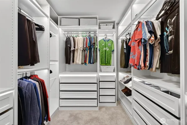 a view of walk in closet with clothes and shoes