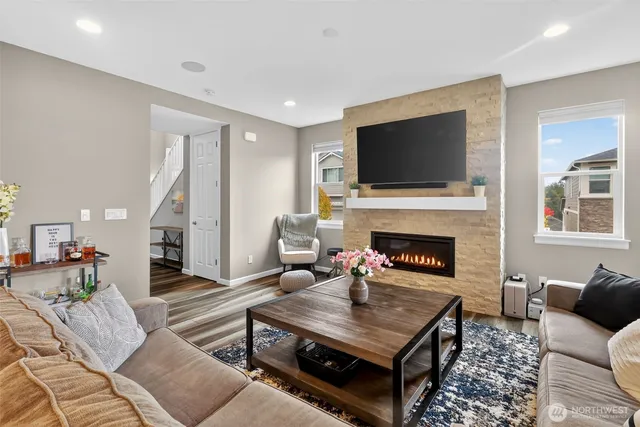 a living room with furniture a flat screen tv and a fireplace