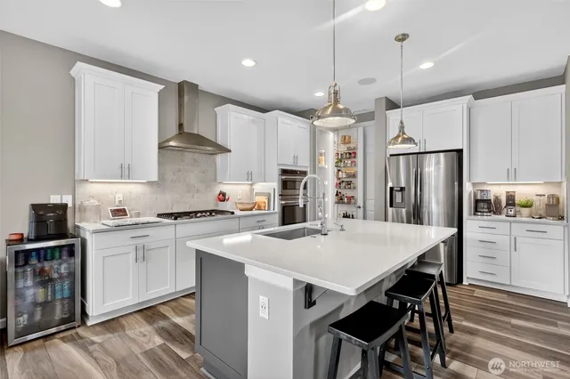 a kitchen with kitchen island a stove a table and chairs