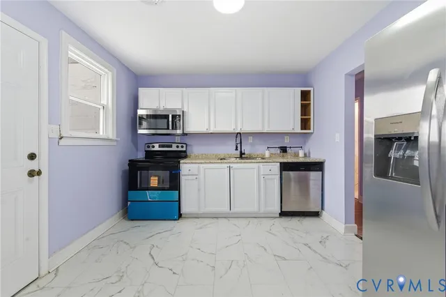 a kitchen with granite countertop a refrigerator stove top oven and sink