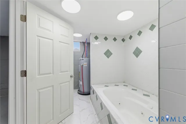 a bathroom with a tub sink and mirror