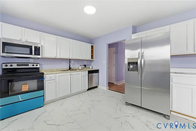 a kitchen with granite countertop a refrigerator and a stove top oven