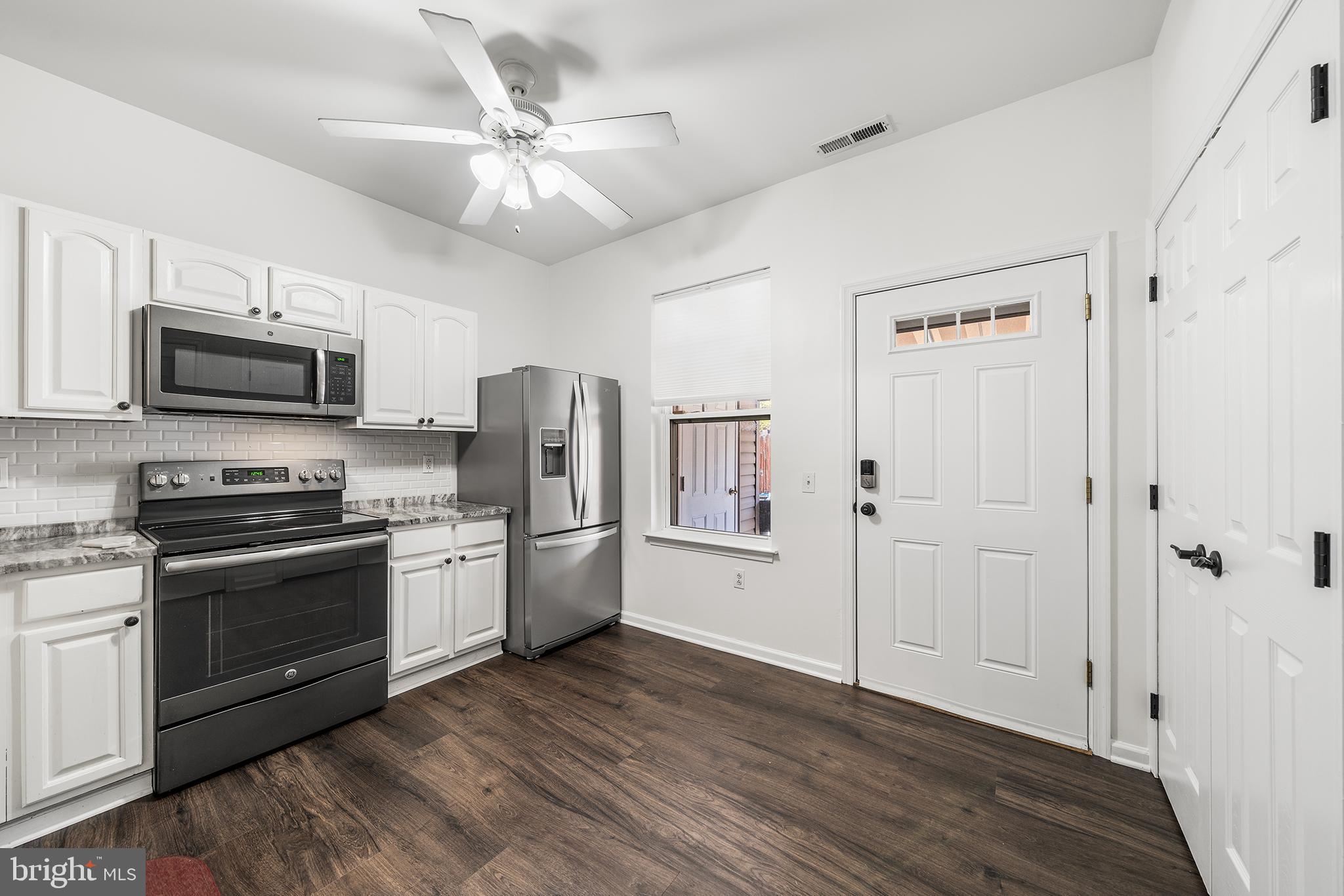 768 South 13th Street Philadelphia, PA 19147 - Photo 12 of 31 a kitchen with stainless steel appliances a stove top oven a refrigerator cabinets and wooden floor