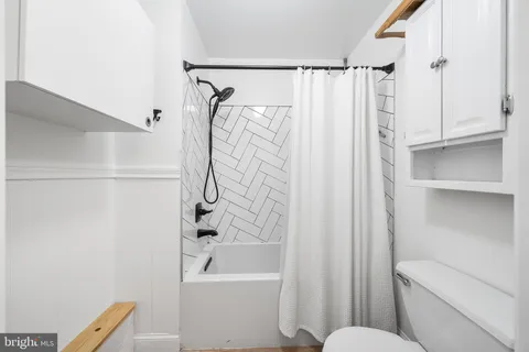 a bathroom with a shower curtain a sink and a toilet