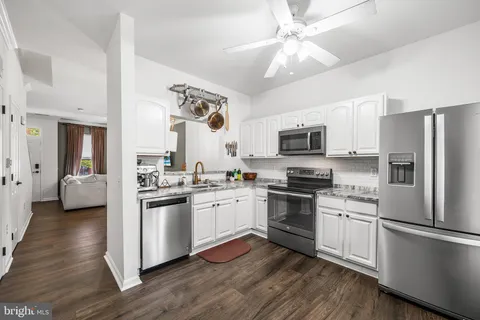 a kitchen with a refrigerator stove top oven and sink