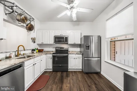 a kitchen with stainless steel appliances a refrigerator a stove sink microwave and cabinets