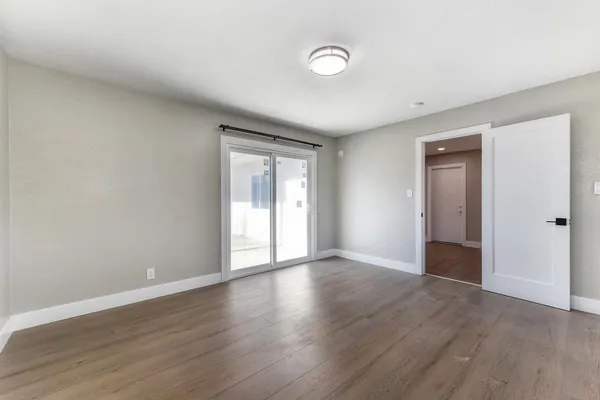 a view of empty room with wooden floor