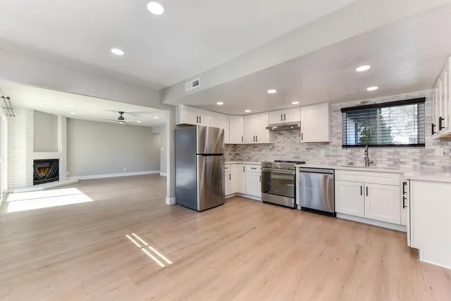 a kitchen with white cabinets sink and stainless steel appliances