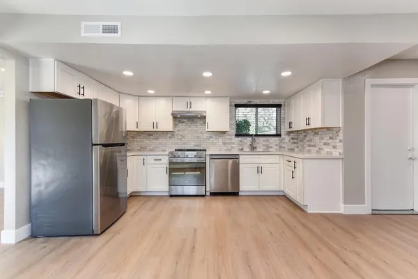 a kitchen with appliances cabinets and a window