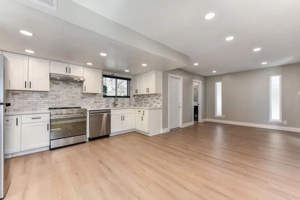 a kitchen with a refrigerator and a stove top oven