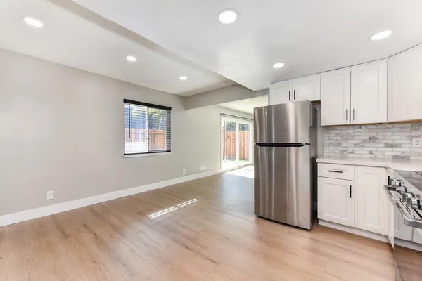 a view of an empty room with a fireplace and a window