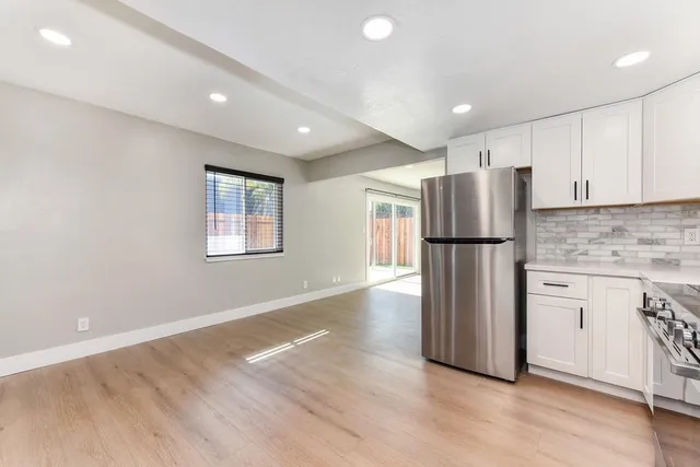 a view of an empty room with a fireplace and a window
