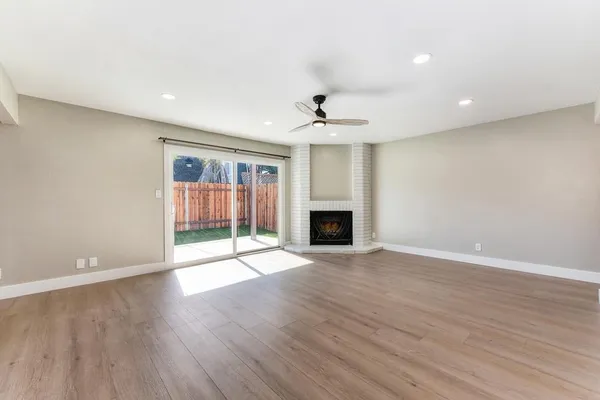 a view of a big room with wooden floor and windows