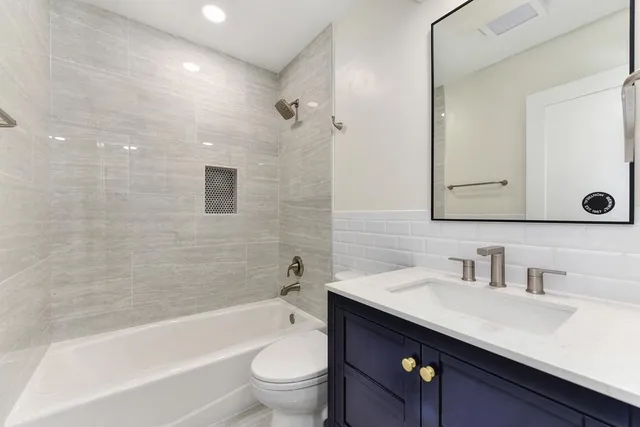 a view of an empty room with wooden floor and a ceiling fan