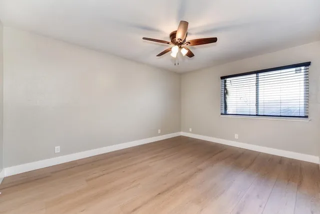 an empty room with closet and fan