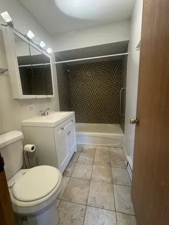 a bathroom with a toilet a sink and mirror