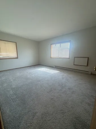an empty room with windows and closet