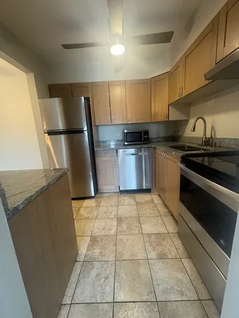 a kitchen with a sink a stove top oven a refrigerator and cabinets