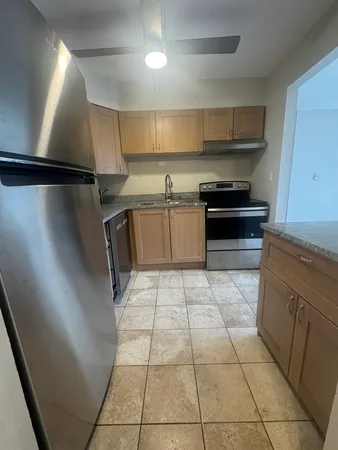 a kitchen with a sink a stove top oven and cabinets