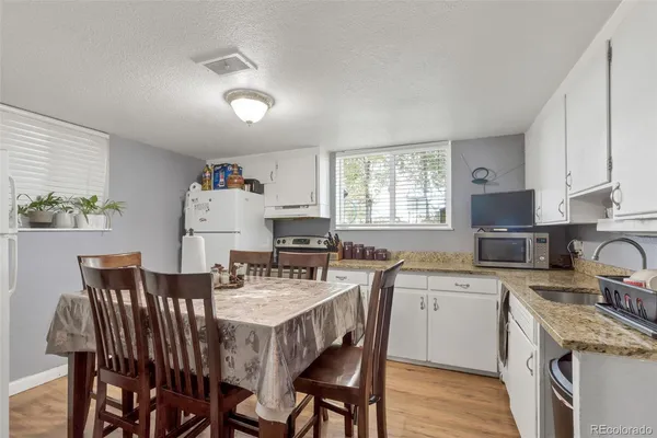 a kitchen with stainless steel appliances granite countertop a stove a refrigerator and a view of dining table