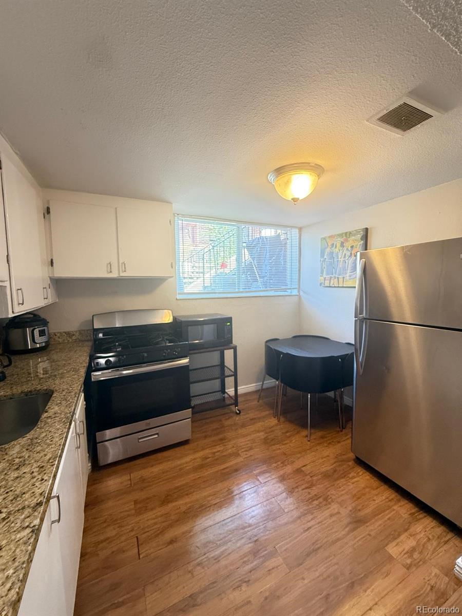 326 South Alcott Street Denver, CO 80219 - Photo 10 of 21 a kitchen with a refrigerator and a stove top oven