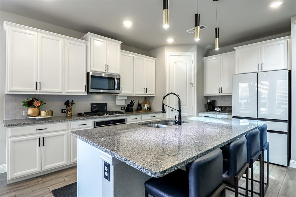 2400 Mill Pl Road Mansfield, TX 76063 - Photo 12 of 32 a kitchen with granite countertop a sink a counter top space appliances and cabinets