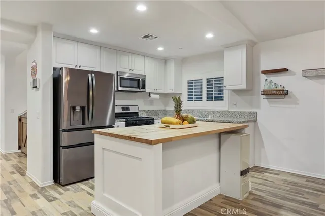 a kitchen with a refrigerator a sink and a microwave