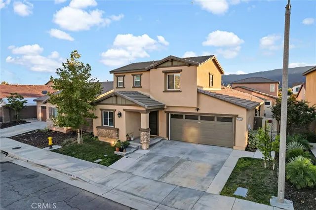a front view of a house with a garden and plants