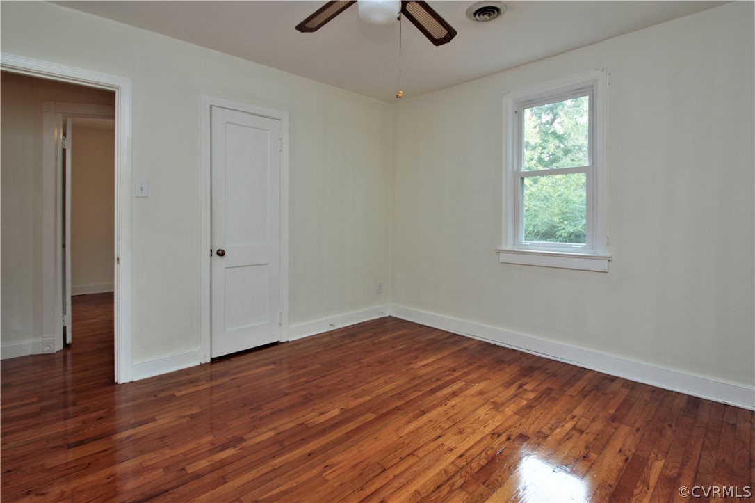 15913 Harrowgate Road Chester, VA 23831 - Photo 8 of 20 an empty room with wooden floor chandelier fan and windows