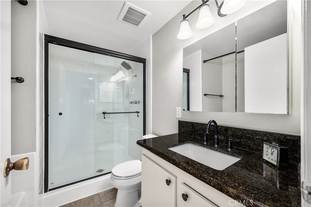 4237 Larwin Avenue Cypress, CA 90630 - Photo 28 of 48 a bathroom with a granite countertop sink mirror vanity and toilet