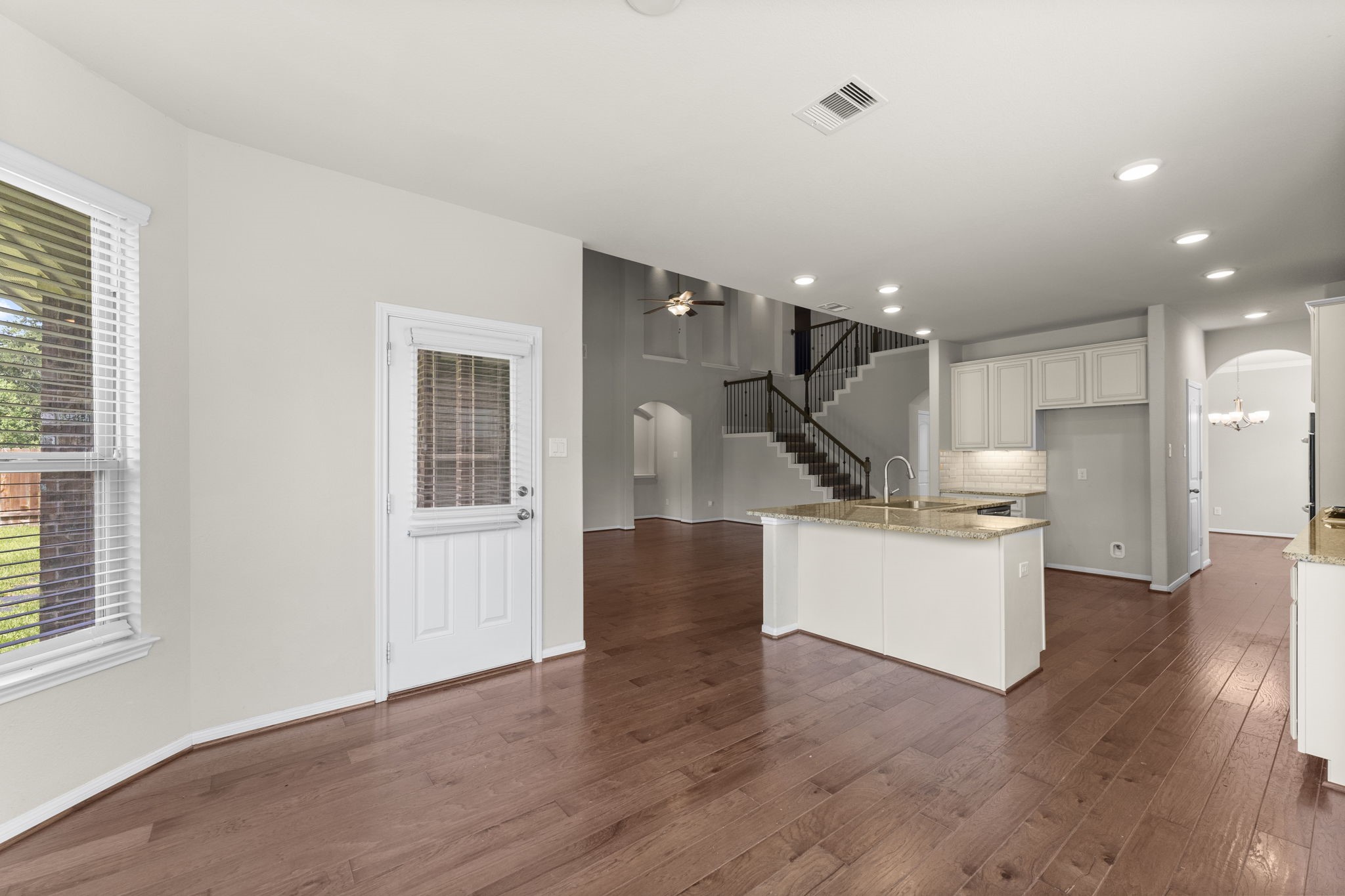 5015 Gold Lantana Trail Spring, TX 77389 - Photo 23 of 50 a open kitchen with white cabinets and wooden floor