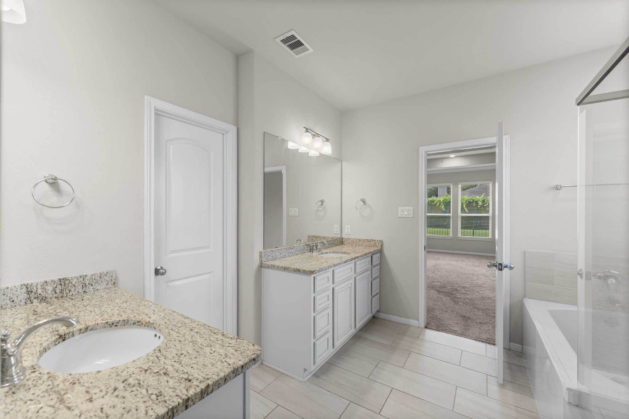 5015 Gold Lantana Trail Spring, TX 77389 - Photo 29 of 50 a bathroom with a granite countertop sink a mirror and a bathtub