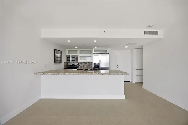 a view of a kitchen with a sink and a refrigerator