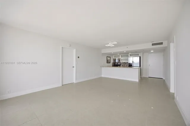a view of an empty room with wooden floor and a floor to ceiling window
