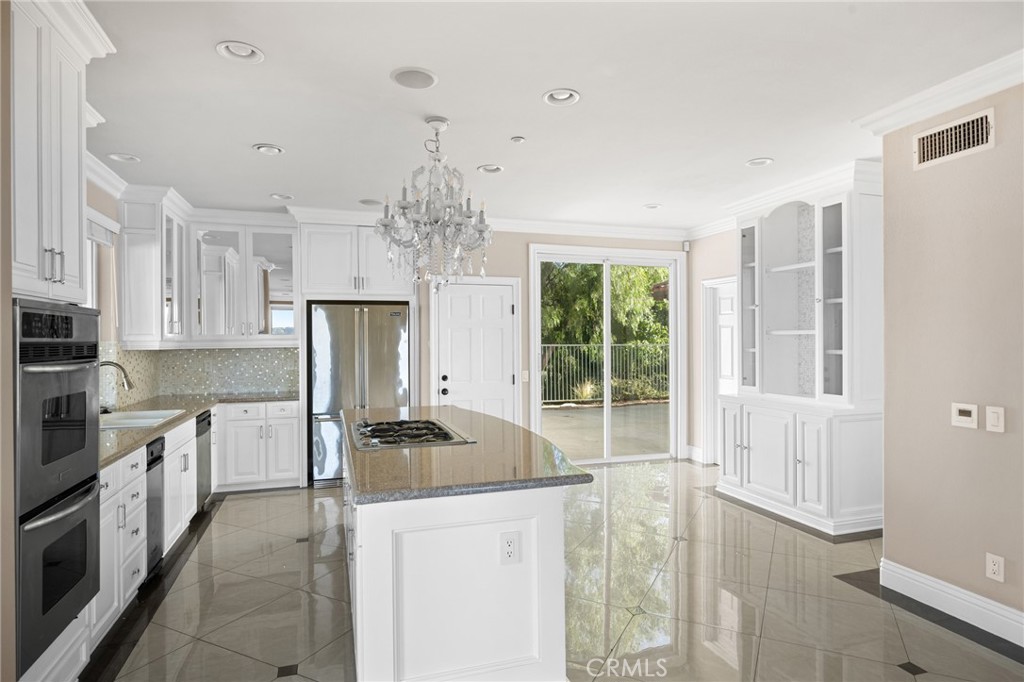 7370 West Chantilly Court Tujunga, CA 91042 - Photo 13 of 55 a kitchen with stainless steel appliances a stove refrigerator sink and cabinets