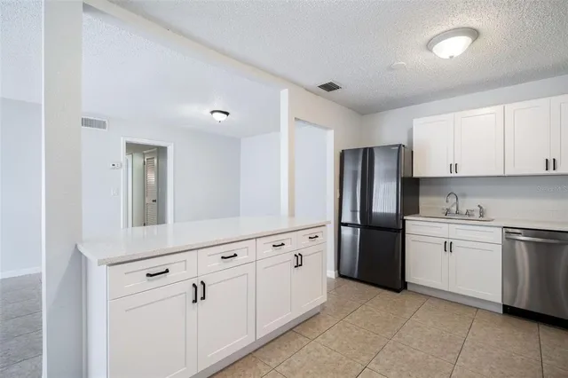 a kitchen with white cabinets and stainless steel appliances