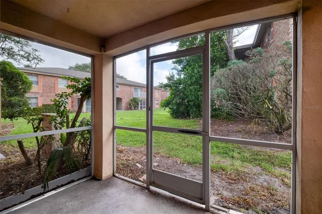 a view of a room with a large window and wooden floor