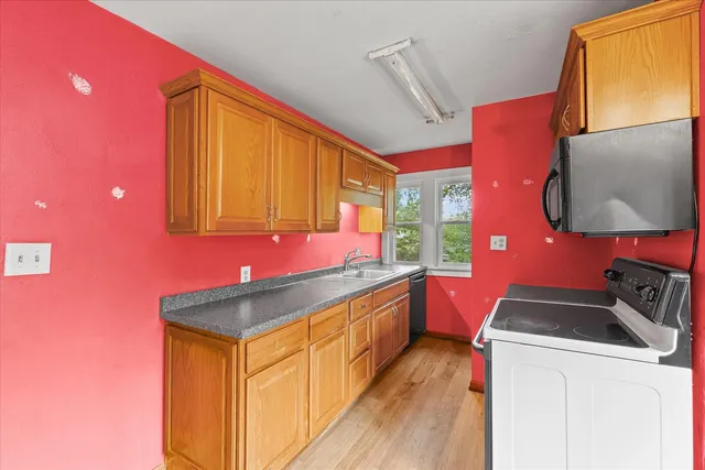 a kitchen with granite countertop a sink and dishwasher a stove top oven