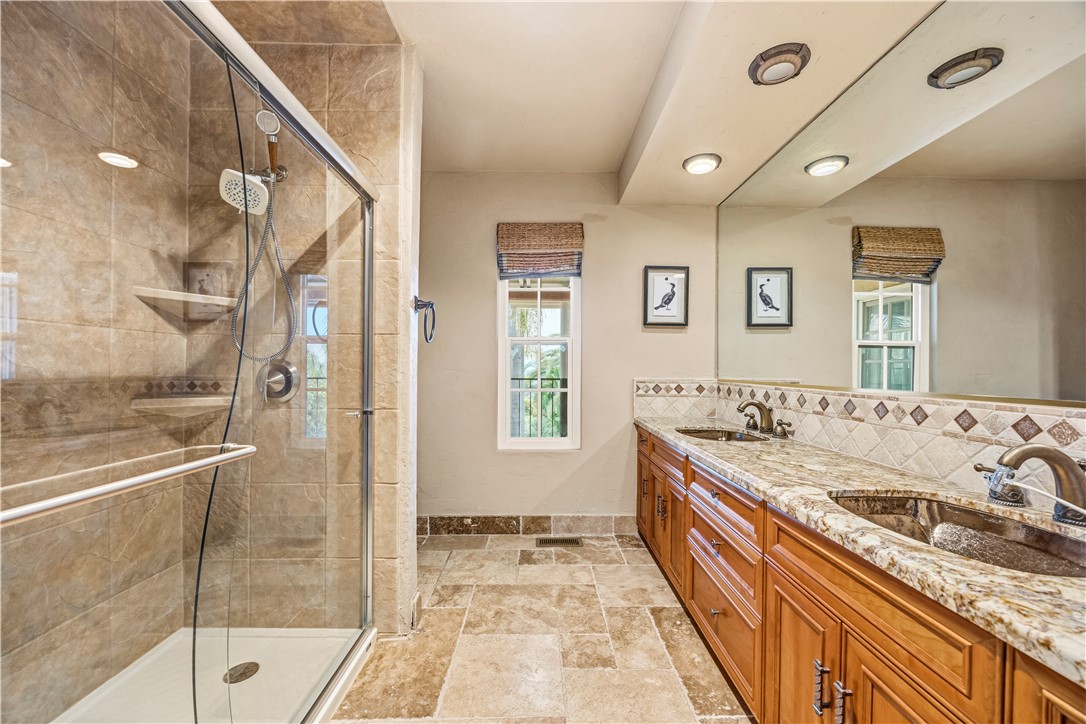 1485 Vía Ladera Fallbrook, CA 92028 - Photo 22 of 43 a bathroom with a granite countertop sink a mirror and shower