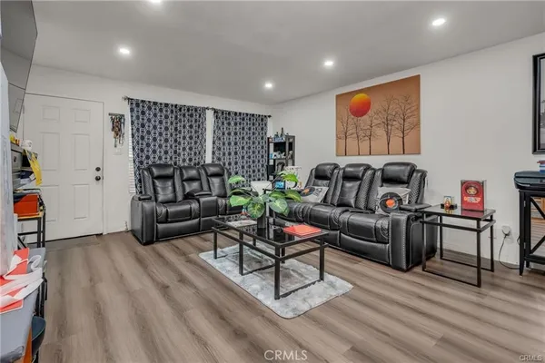a living room with furniture and a wooden floor