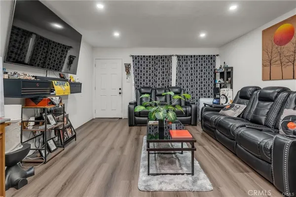 a living room with furniture a wooden floor and a flat screen tv