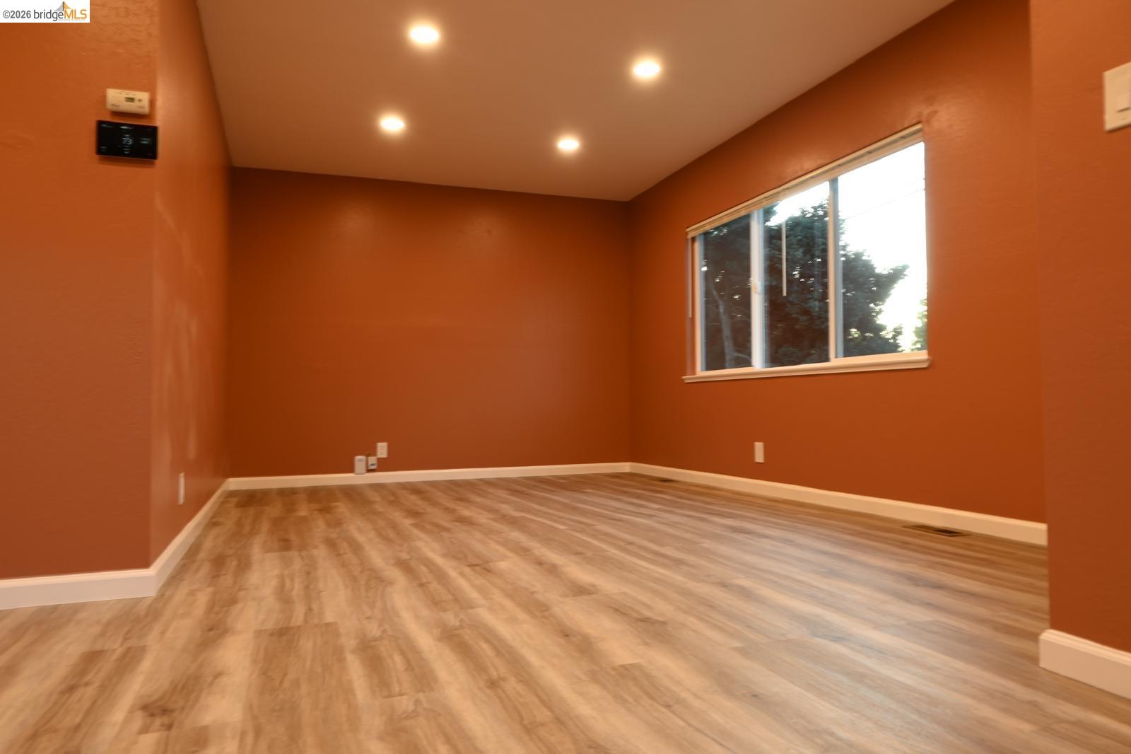 1316 Russell Street Berkeley, CA 94702 - Photo 4 of 23 a view of an empty room with wooden floor and a window