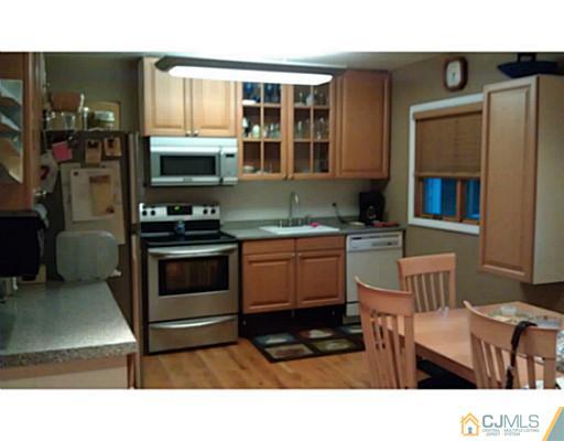 3046 Cheesequake Road Old Bridge, NJ 08859 - Photo 13 of 16 a kitchen with stainless steel appliances kitchen island granite countertop a stove a sink and a microwave